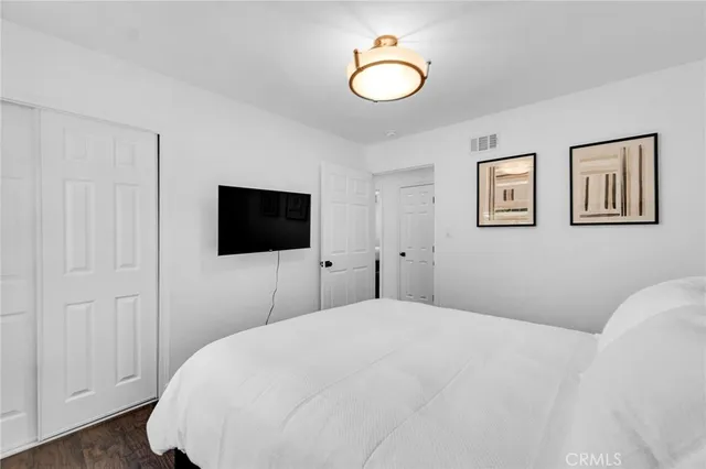 a bedroom with a bed and a flat screen tv