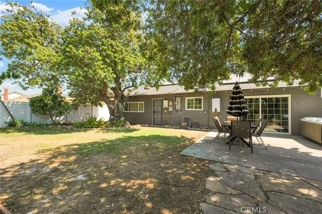 a view of a house with backyard and a tree