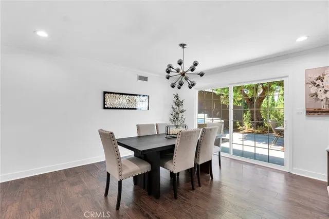 a view of a dining room with furniture wooden floor and a potted plant