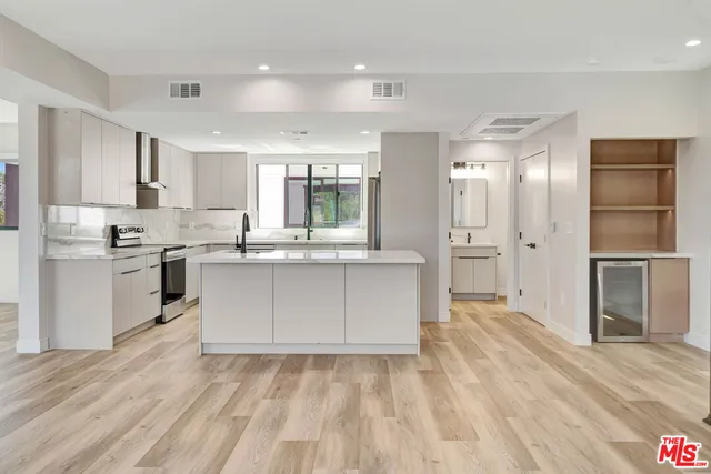 a large kitchen with kitchen island a sink stainless steel appliances and cabinets