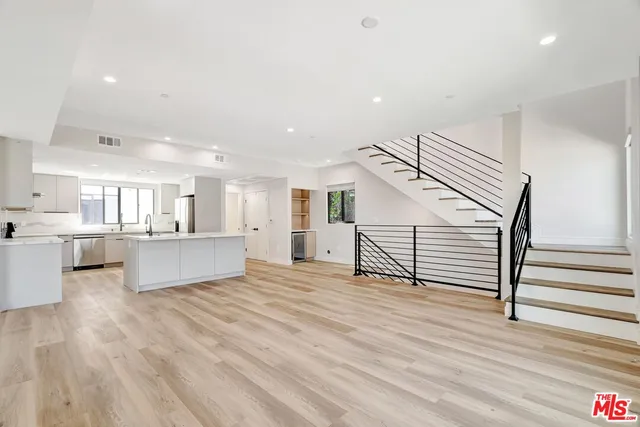 a view of a kitchen with wooden floor and a sink