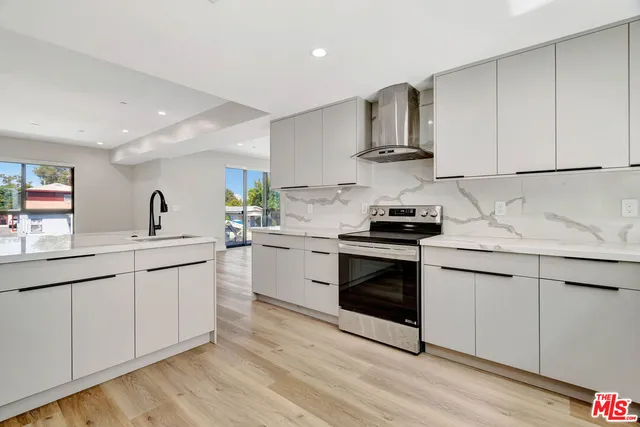 a kitchen with granite countertop a sink stainless steel appliances and cabinets