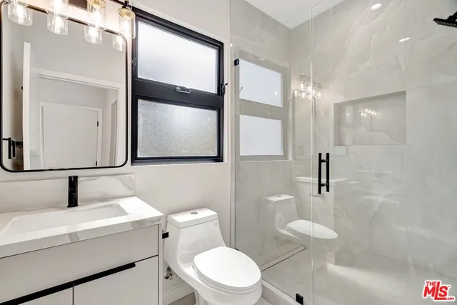 a bathroom with a toilet a sink and a mirror