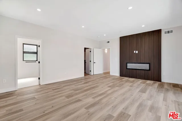 a big room with wooden floor and bathroom view
