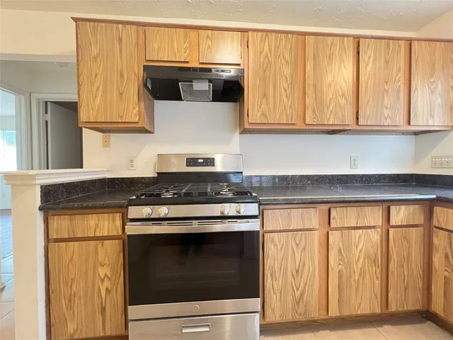 a kitchen with granite countertop white cabinets and black stainless steel appliances