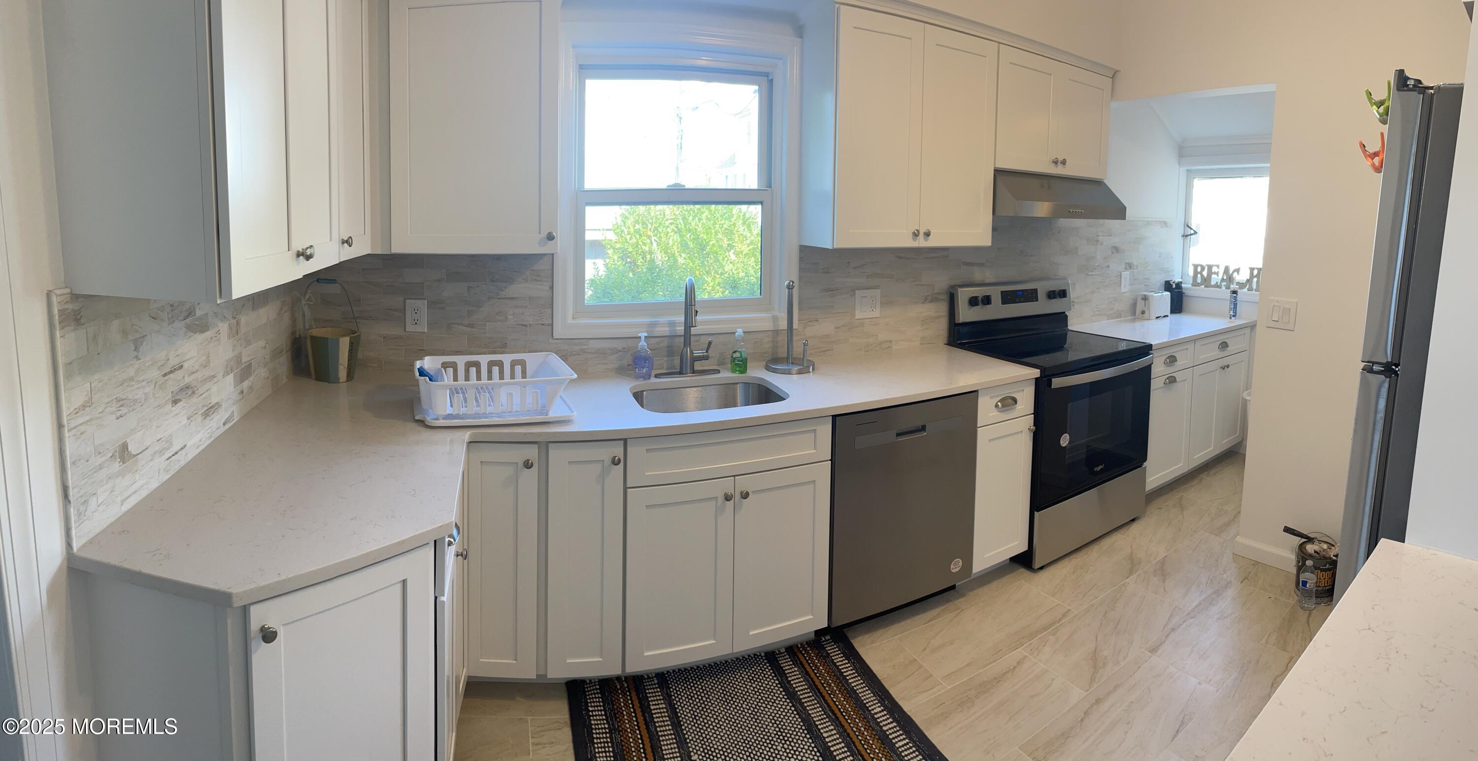 411 Fifth Avenue Avon-by-the-Sea, NJ 07717 - Photo 2 of 5 a kitchen with stainless steel appliances granite countertop a sink stove and refrigerator