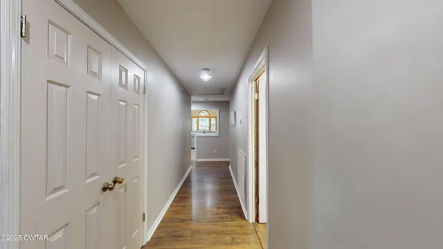 a view of a hallway with wooden floor and staircase