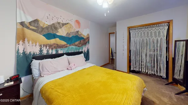 a bedroom with a bed and a painting on the wall