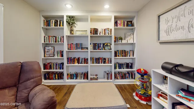 a living room with lots of books and a book shelf