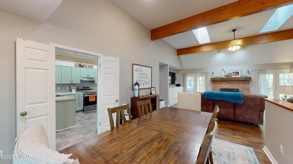 a living room with furniture a dining table and chairs with wooden floor