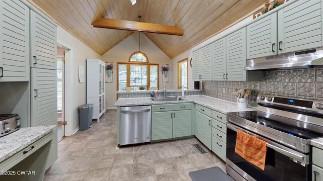 a open kitchen with stainless steel appliances granite countertop a stove and a sink
