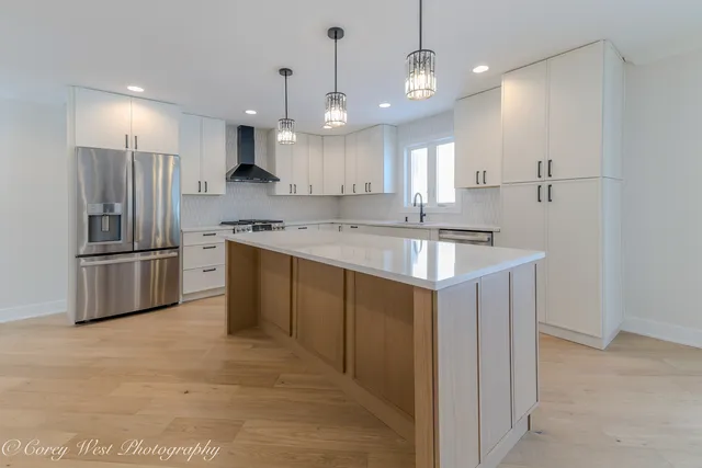 a kitchen with stainless steel appliances a refrigerator sink and cabinets
