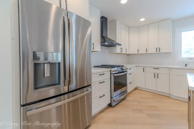 a kitchen with stainless steel appliances granite countertop a sink a stove a refrigerator and island