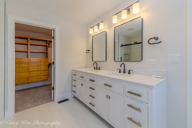 a bathroom with double sink and a mirror