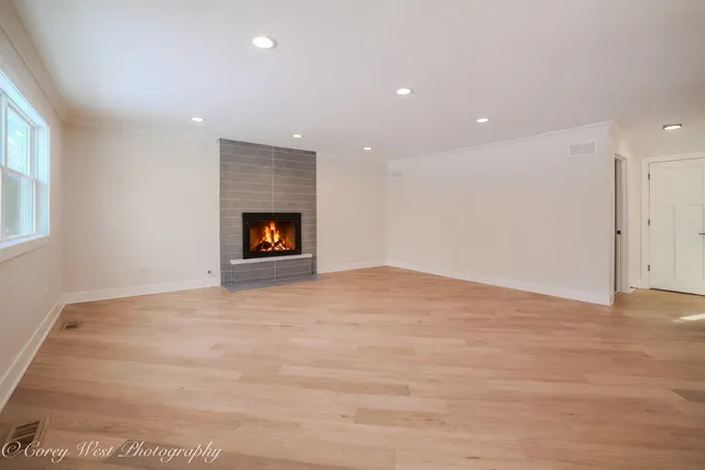 a view of an empty room with window and fire place