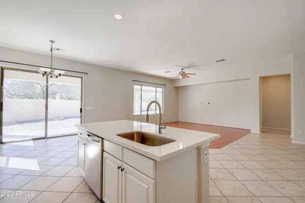 a kitchen with granite countertop a sink a stove and cabinets