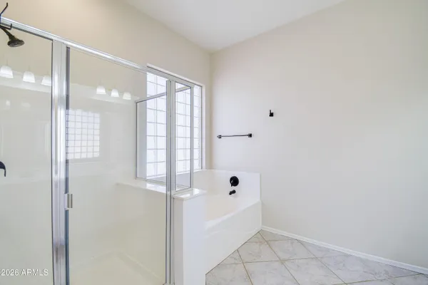 a bathroom with a double vanity sink a large mirror and a bathtub
