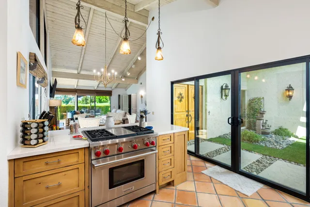 a kitchen with a stove a sink and a large window