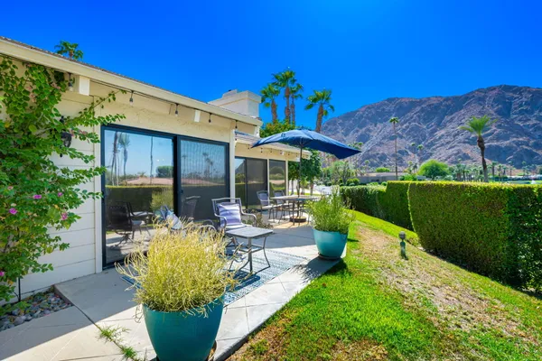 a view of a house with backyard sitting area and garden