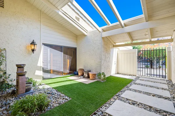 a backyard of a house with a garden and outdoor seating