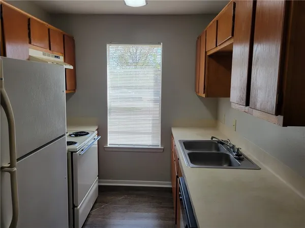 a kitchen with a refrigerator a sink and a window