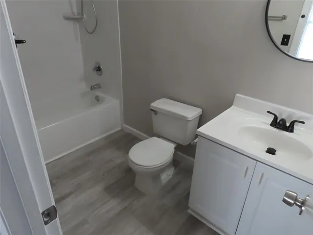 a white toilet sitting next to a bath tub