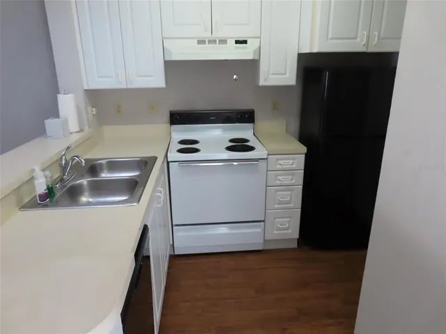 a kitchen with a stove sink and cabinets