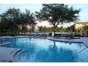 a view of swimming pool with outdoor seating and trees