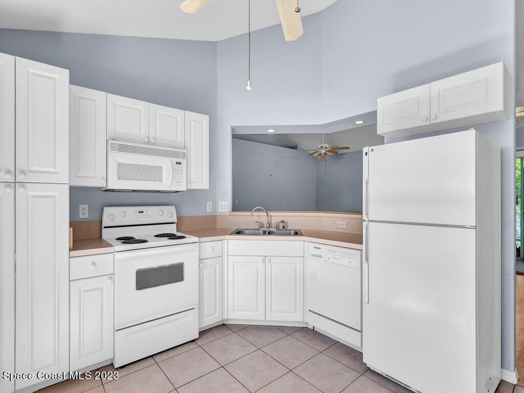 534 Sloane Street Sebastian, FL 32958 - Photo 17 of 36 a kitchen with white cabinets and white appliances