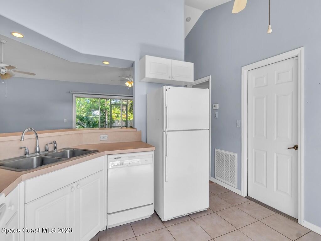 534 Sloane Street Sebastian, FL 32958 - Photo 18 of 36 a kitchen with a refrigerator sink and cabinets