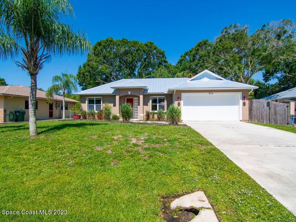 534 Sloane Street Sebastian, FL 32958 - Photo 2 of 36 a front view of a house with a garden