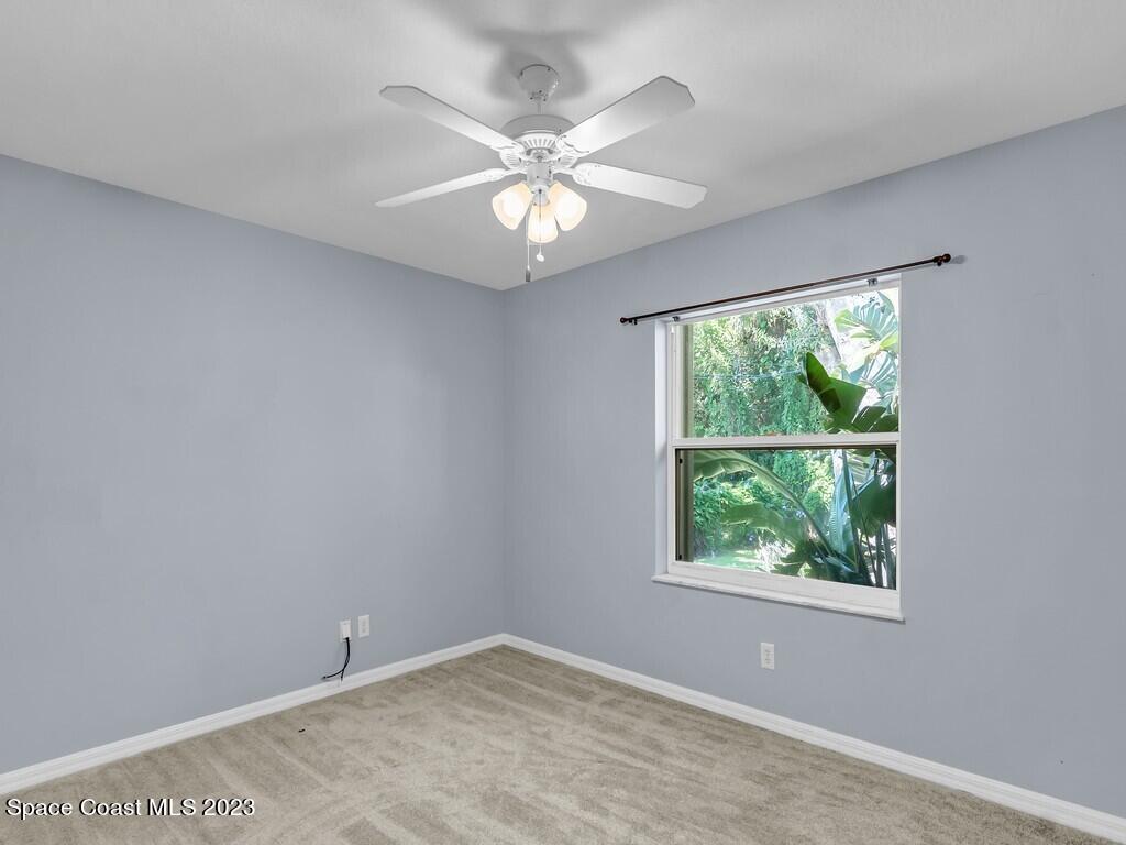 534 Sloane Street Sebastian, FL 32958 - Photo 23 of 36 an empty room with windows and ceiling fan