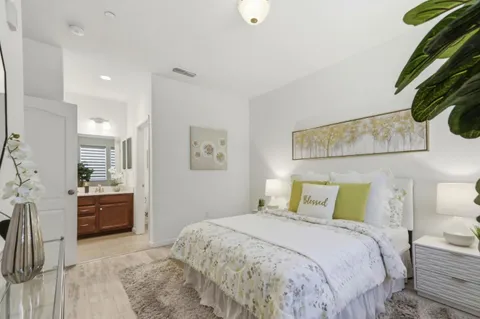 a bedroom with a bed and dresser with mirror