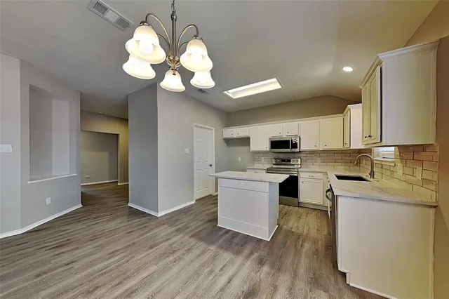a kitchen with a white cabinets stove and refrigerator