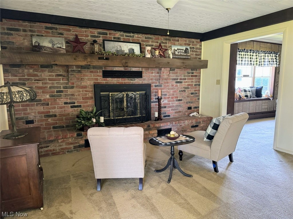 1639 Stonehaven Road Madison, OH 44057 - Photo 12 of 35 Carpeted living room featuring brick wall and a brick fireplace