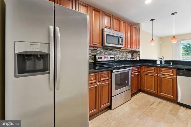 a kitchen with stainless steel appliances granite countertop a stove and a refrigerator