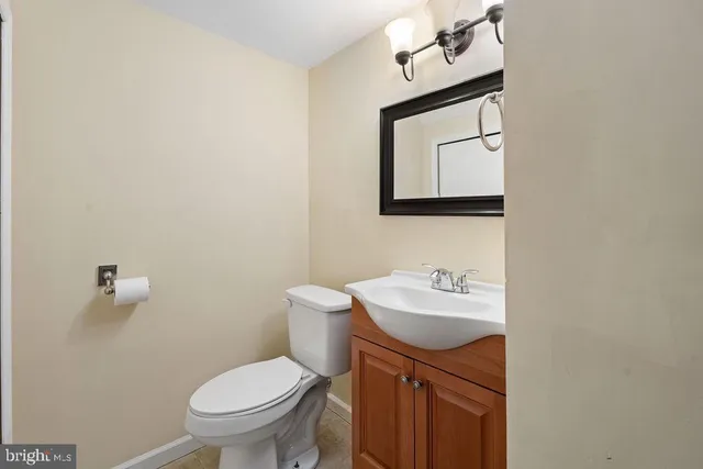 a bathroom with a toilet a sink and mirror