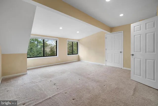 an empty room with closet and natural light