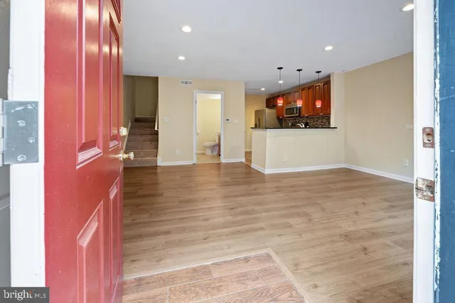 an empty room with wooden floor and windows