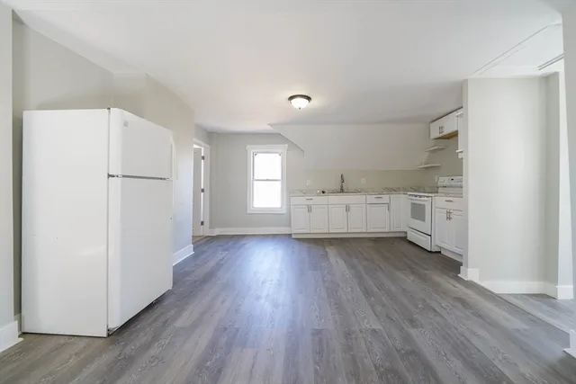 a view of a kitchen with a white cabinets and wooden floor