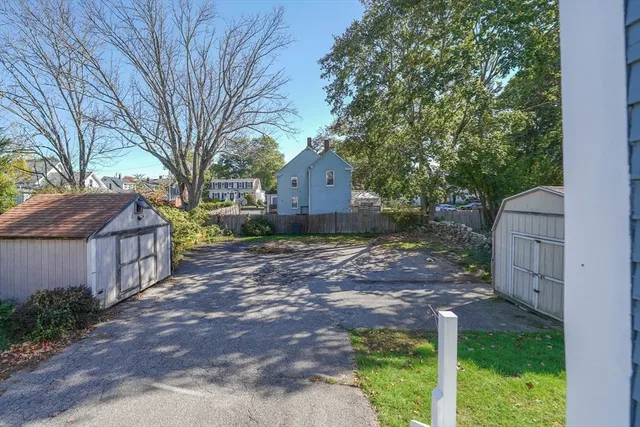 a backyard of a house with wooden fence and large trees