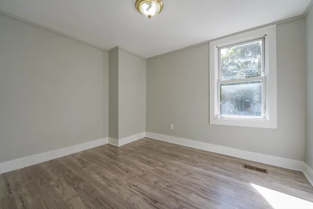 wooden floor in an empty room with a window