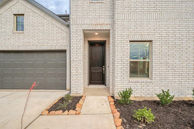 a view of a brick house with potted plants