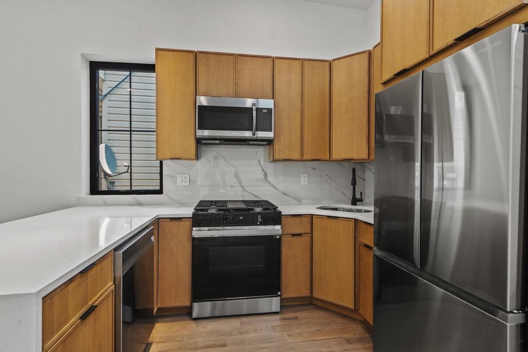 41 47th Street, Unit 2 Weehawken, NJ 07086 - Photo 13 of 22 a kitchen with stainless steel appliances granite countertop a stove a refrigerator and a sink