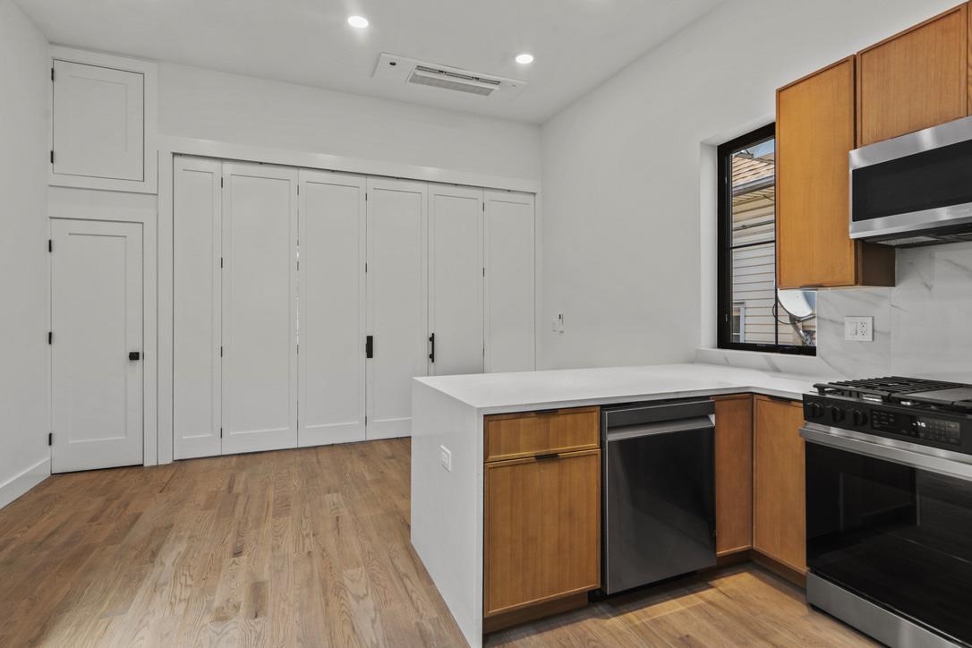 41 47th Street, Unit 2 Weehawken, NJ 07086 - Photo 15 of 22 a kitchen with stainless steel appliances granite countertop a stove and a sink