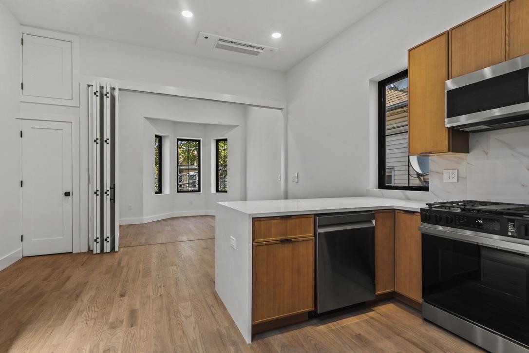 41 47th Street, Unit 2 Weehawken, NJ 07086 - Photo 18 of 22 a kitchen with stainless steel appliances granite countertop a stove and a sink