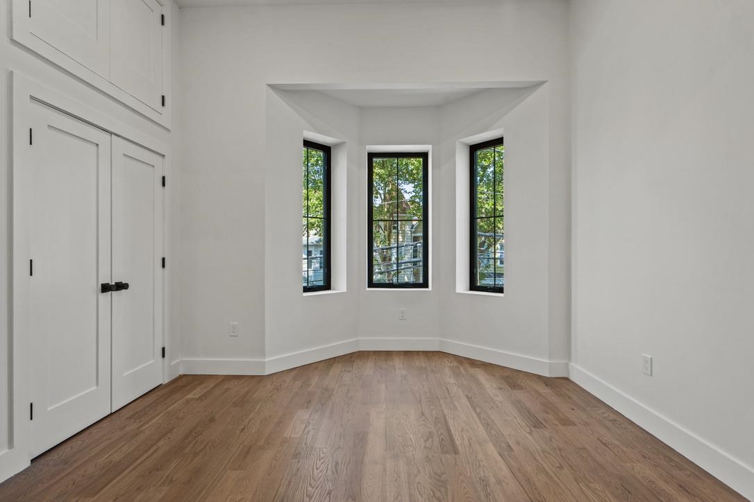41 47th Street, Unit 2 Weehawken, NJ 07086 - Photo 8 of 22 a view of an empty room with wooden floor and a window