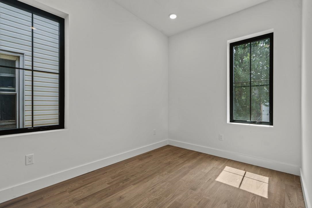 41 47th Street, Unit 2 Weehawken, NJ 07086 - Photo 10 of 22 an empty room with wooden floor and windows