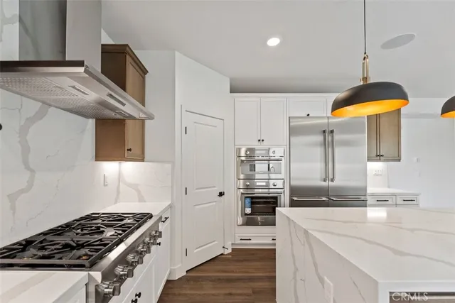 a kitchen with stainless steel appliances granite countertop a sink a stove and a refrigerator