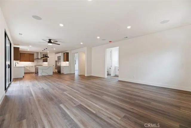 a view of an empty room and a kitchen
